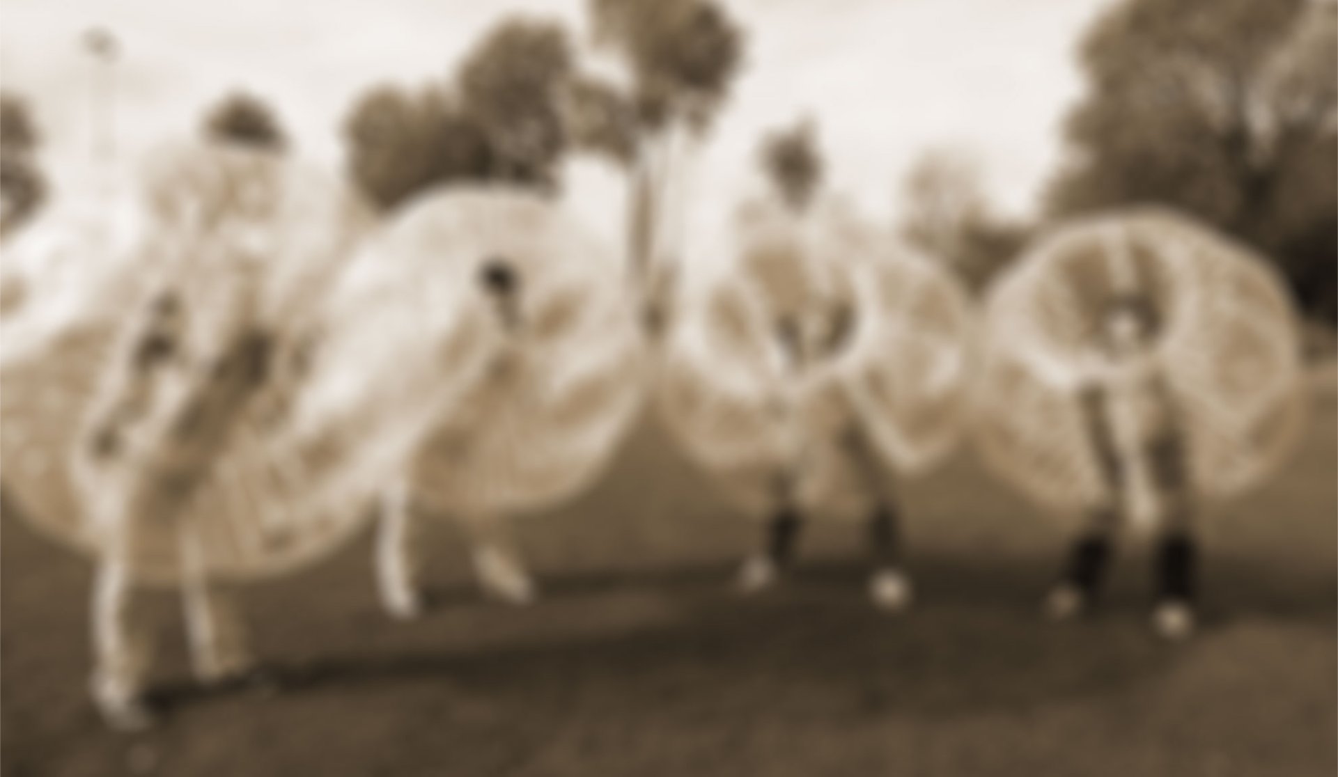 Vier gut gelaunte Männer in jeweils einem Bubbleball posen für das Foto Bubbleball mit Vier Mann